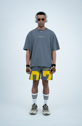 Model in the Haresquare Steey Grey T-shirt with a Yellow print, styled with Haresquare Grey shorts and designer sunglasses – unisex luxury sportswear from Ireland.